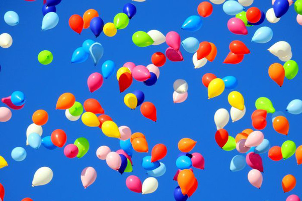 Färgade ballonger mot blå himmel