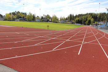 Röda löparbanor och en gräsplan vid Trollbäckens idrottsplats.